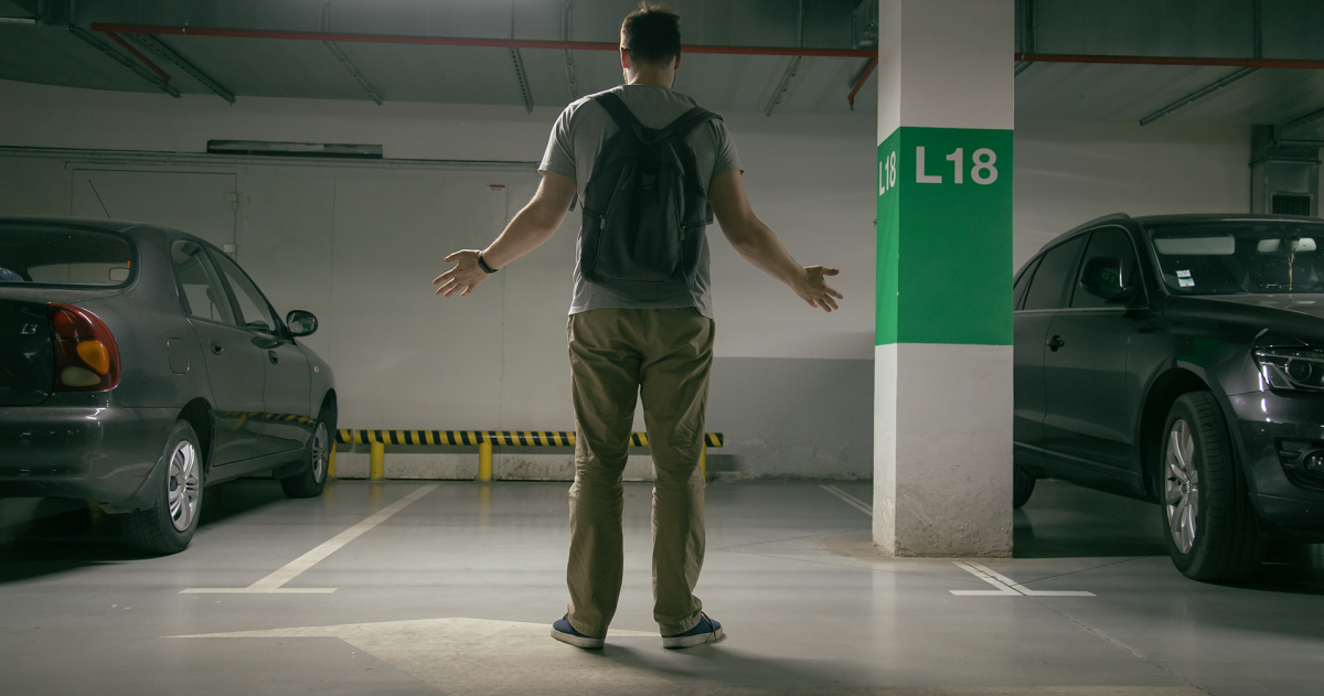 gestolen auto; man met armen op zij komt in de parkeergarage en zijn auto is weg